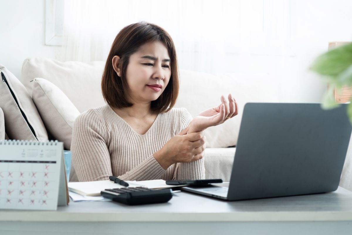 Woman experiencing carpal tunnel and wrist pain while working seeking non-surgical treatment in Charlotte NC